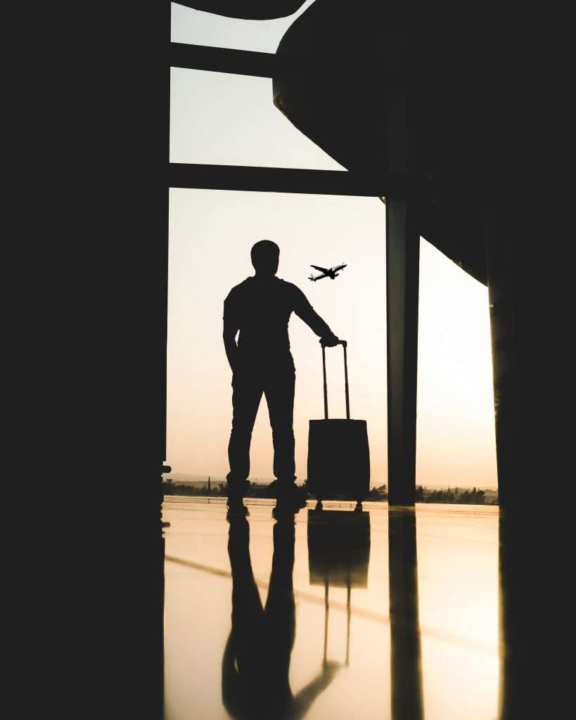 man standing at airport watching planes